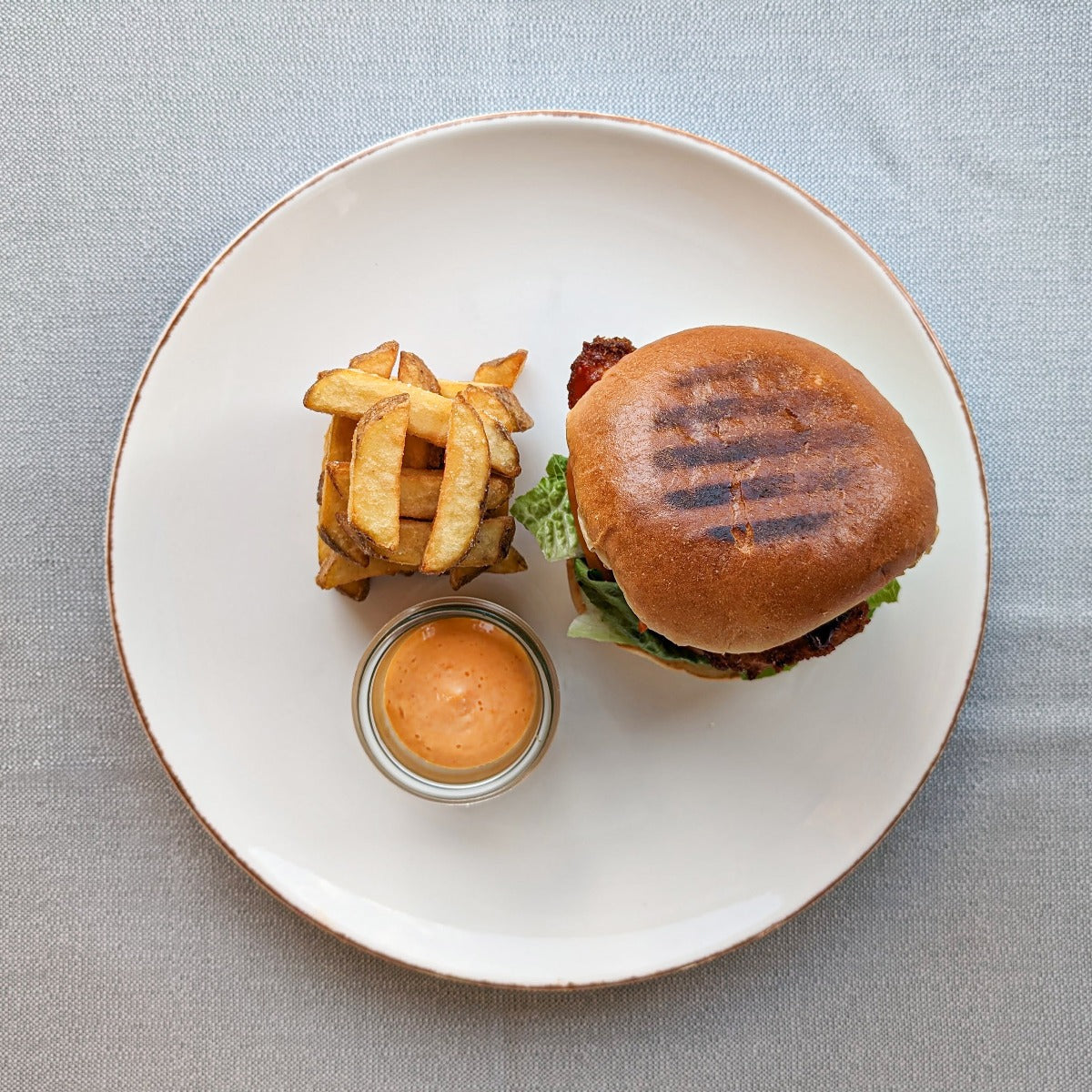 Burger med sprød kylling, barbecuesauce, kimchi og grove fritter