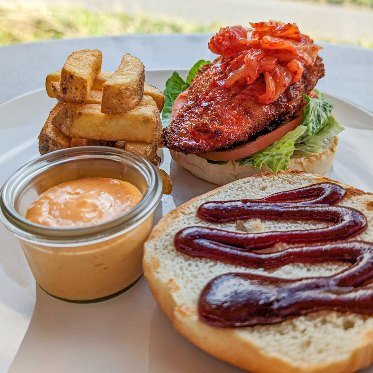 Burger med sprød kylling, barbecuesauce, kimchi og grove fritter