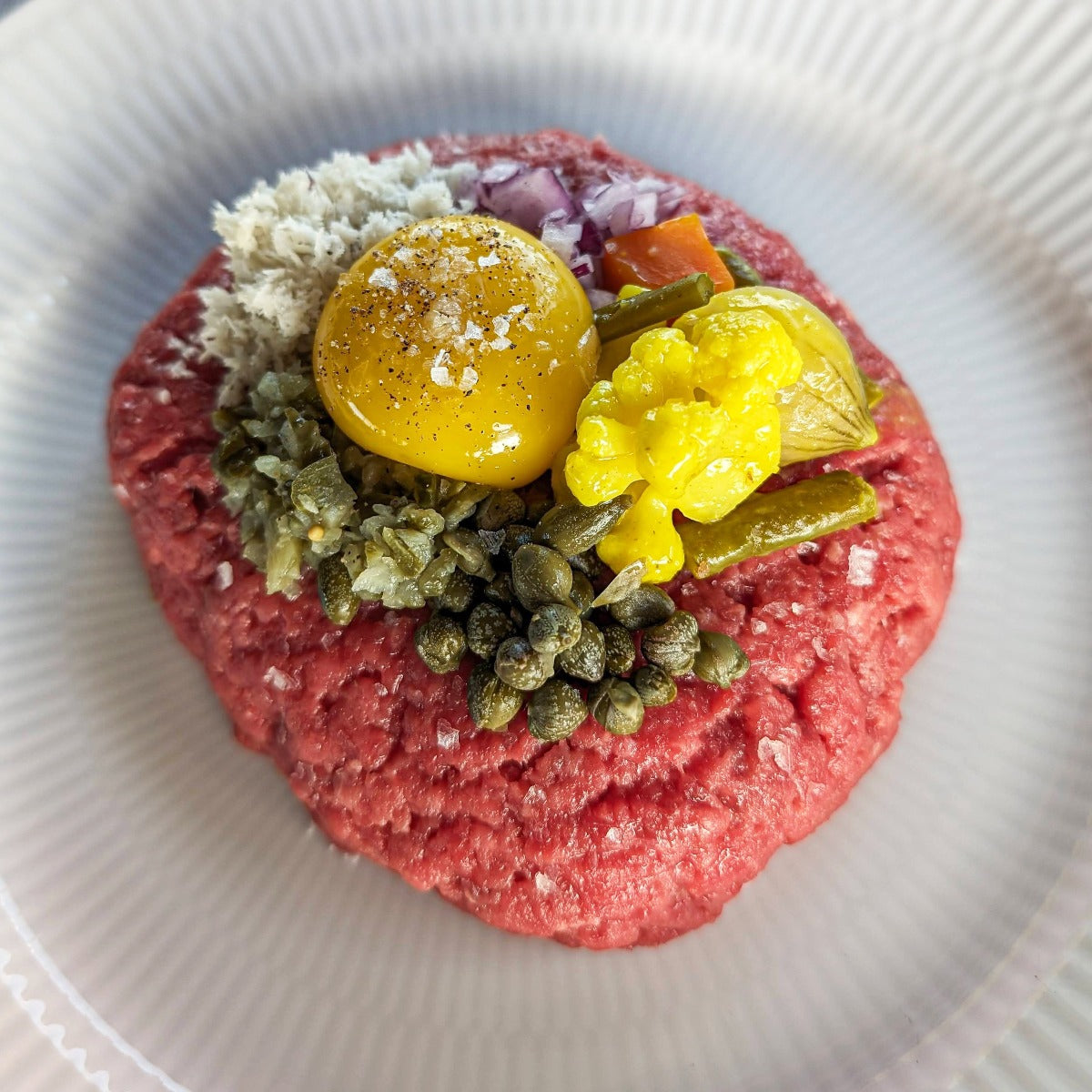 Oksetatar med æggeblomme, løg, kapers, pickles og peberrod
